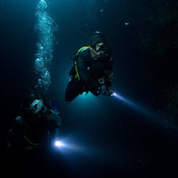 night-dive-divers-with-dive-lamp